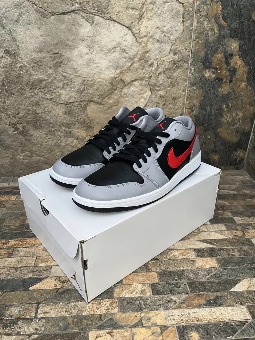Air Jordan 1 Low Cement Grey / Fire Red. Par completo sobre su caja, vista de tres cuartos