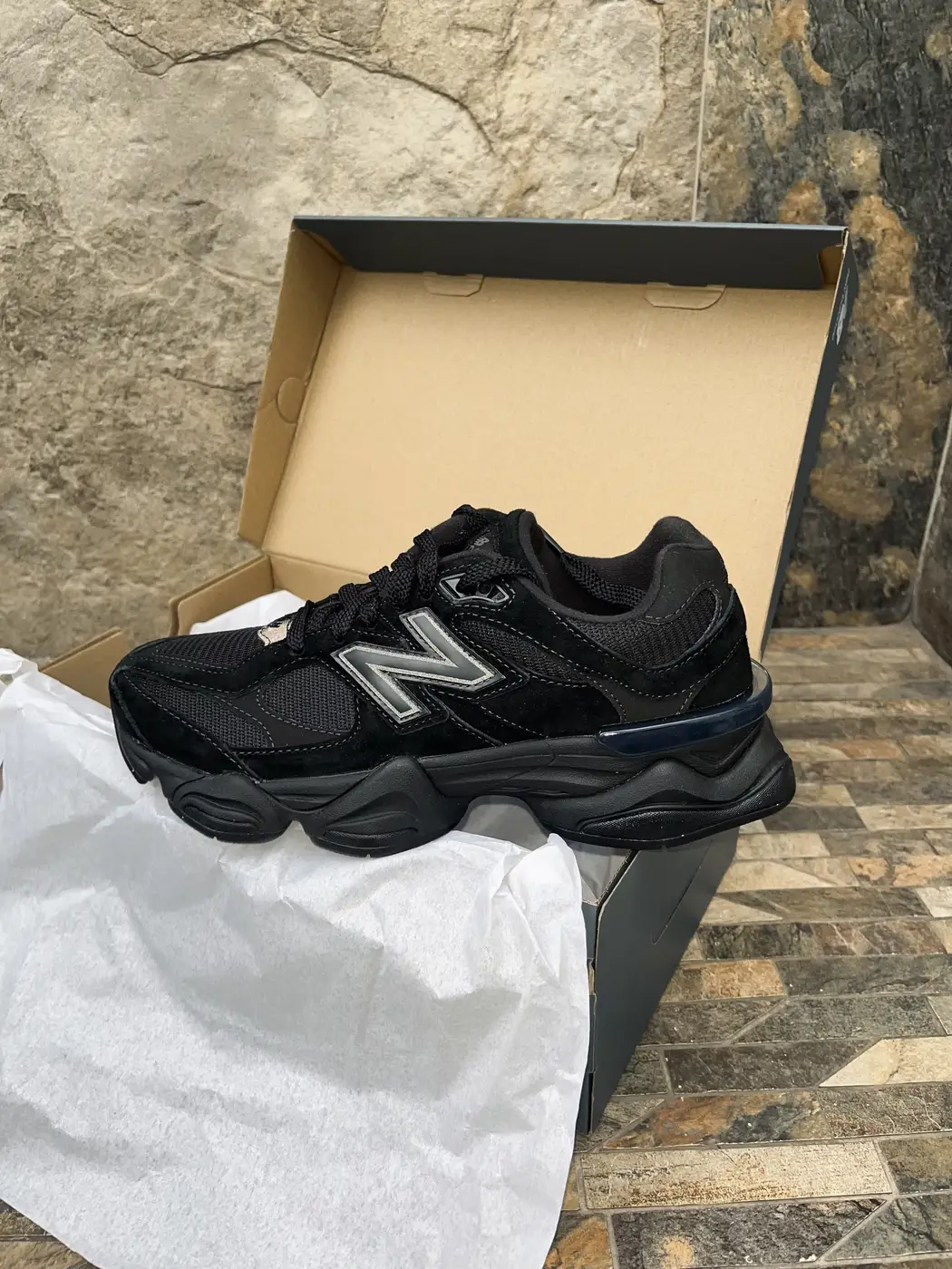 New Balance Negro (modelo por confirmar). Perfil del pie derecho frente a la caja